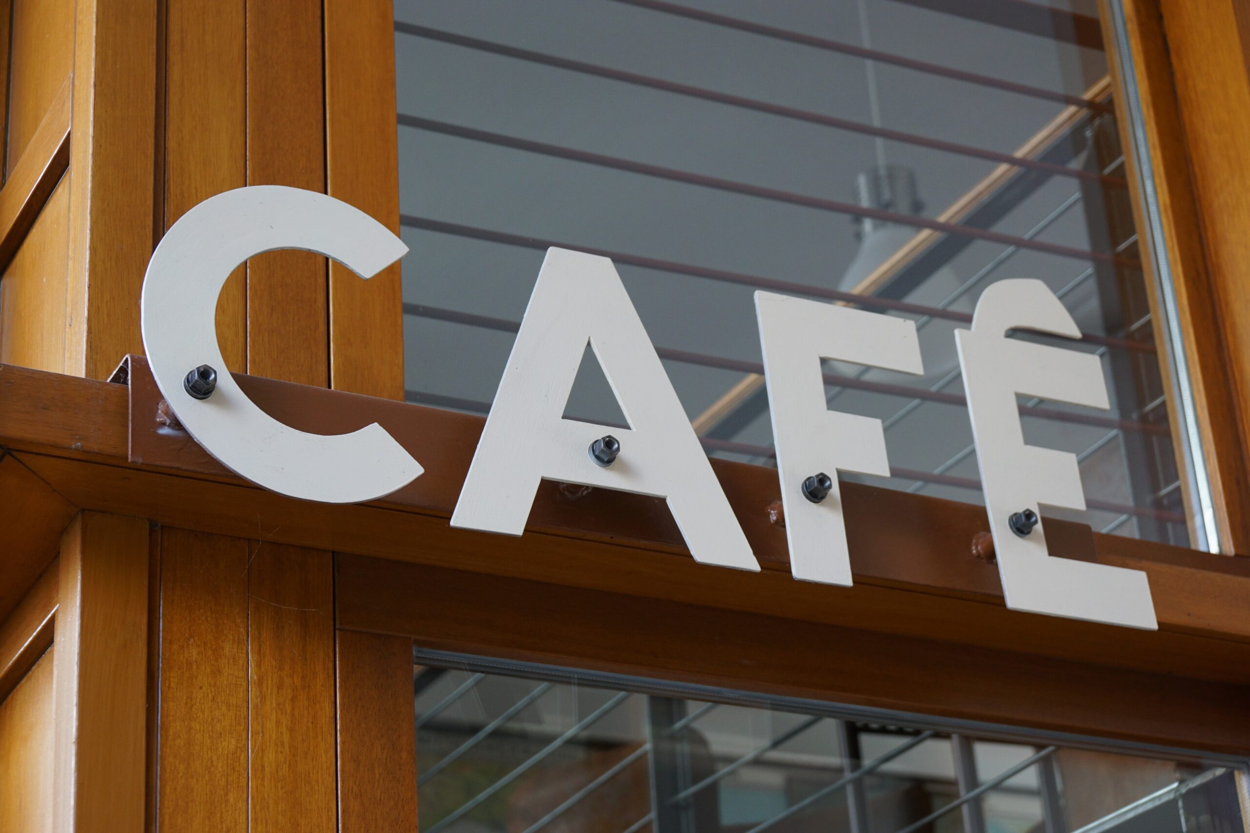 Closeup of a cafe sign on fixed on a wooden beam of a shop